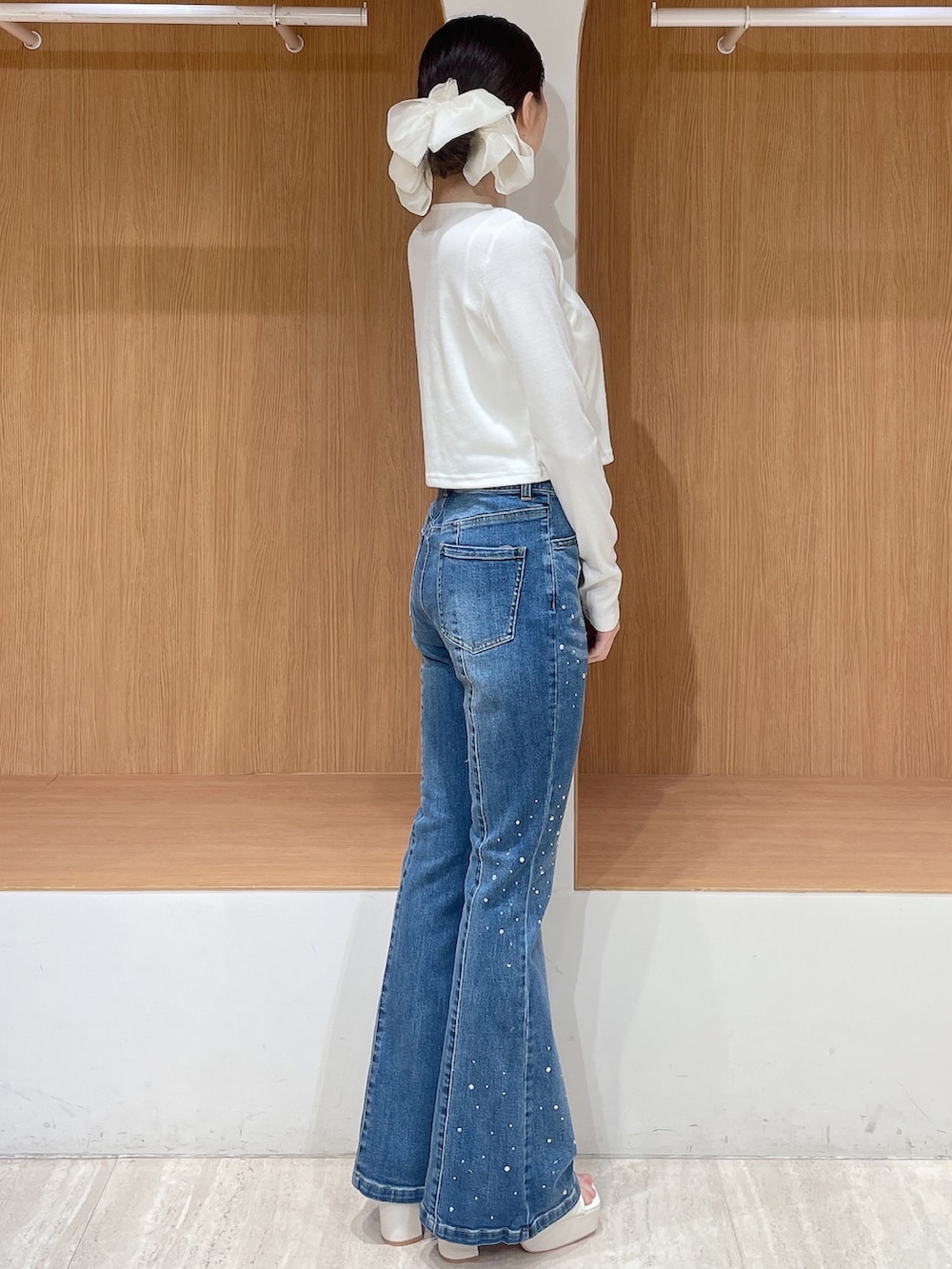 ホワイト系のカーディガン/ボレロ、ブルー系のデニムパンツ、ホワイト系のサンダルを着用したレディースの春コーディネートの2枚目の写真