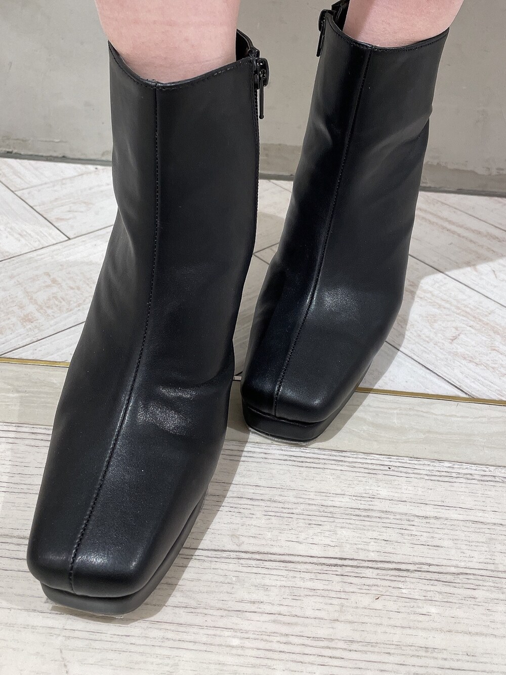 ホワイト系のテーラードジャケット、ホワイト系のスカート、ブラック系のニット/セーターを着用したレディースの冬コーディネートの8枚目の写真