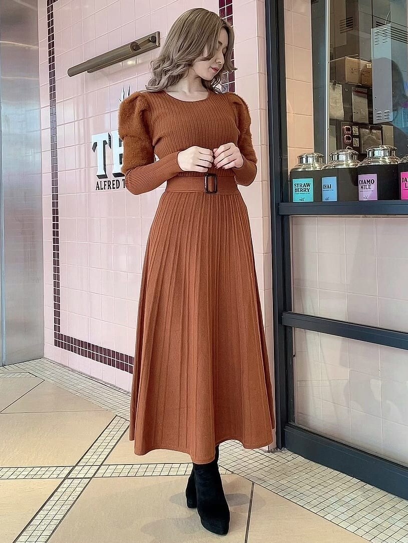 ブラック系のブーツ、オレンジ系のワンピースを着用したレディースの冬コーディネートの2枚目の写真