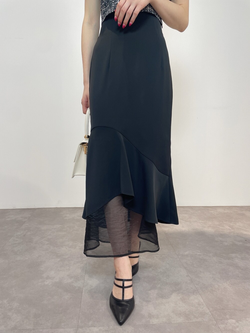 ブラック系のシャツ/ブラウス、ホワイト系のハンドバッグ、ブラック系のパンプスを着用したレディースの春コーディネートの9枚目の写真