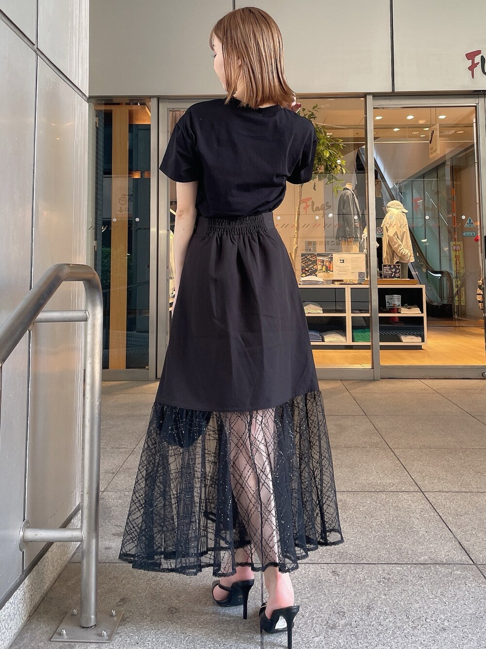 ブラック系のスリッポン、ブラック系のTシャツ/カットソー、ブラック系のスカートを着用したレディースの夏コーディネートの5枚目の写真