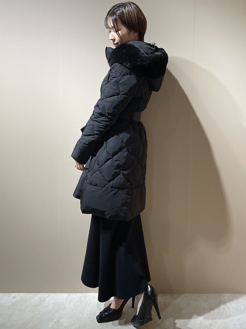 ブラック系のダウンジャケット/コート、ブラック系のワンピース、ブラック系のパンプスを着用したレディースの秋コーディネートの3枚目の写真