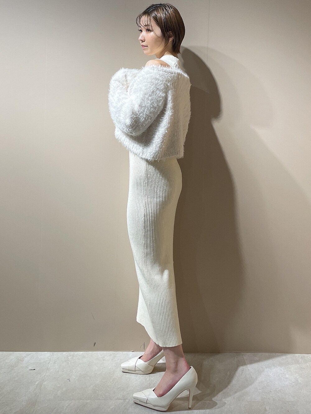 ホワイト系のワンピース、ホワイト系のダウンジャケット/コート、ホワイト系のパンプスを着用したレディースの秋コーディネートの2枚目の写真