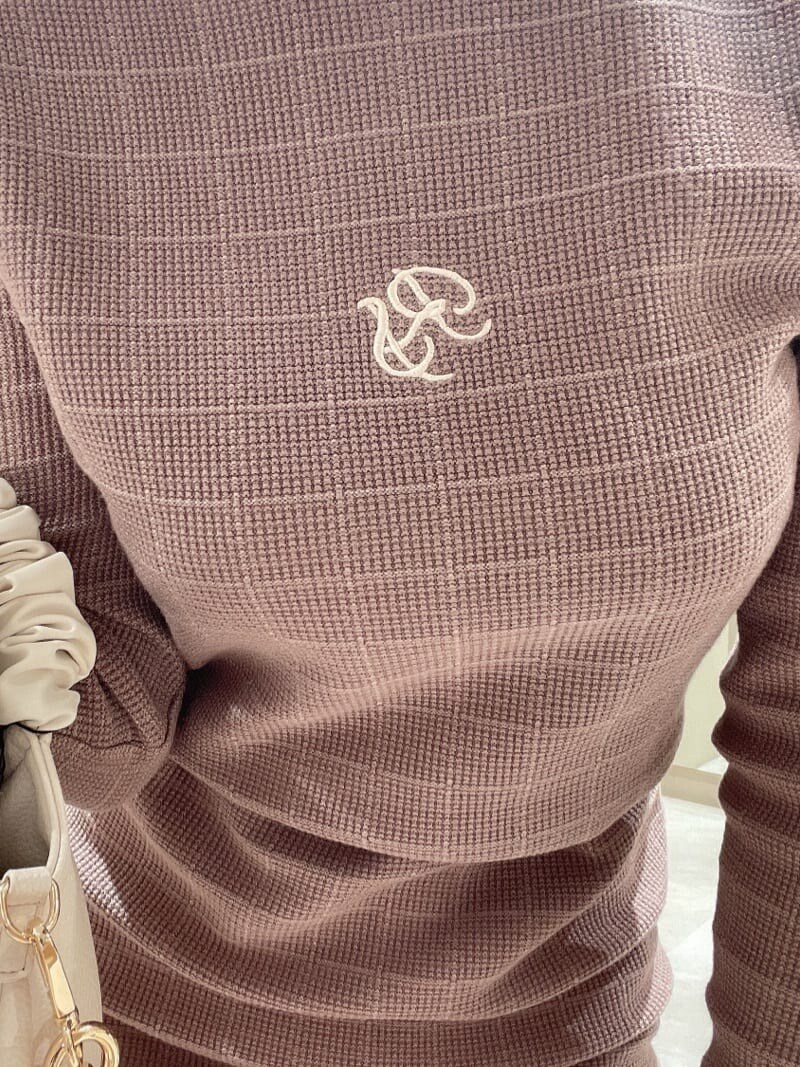 ブラック系のブーツ、ベージュ系のワンピース、ホワイト系のハンドバッグを着用したレディースの秋コーディネートの4枚目の写真