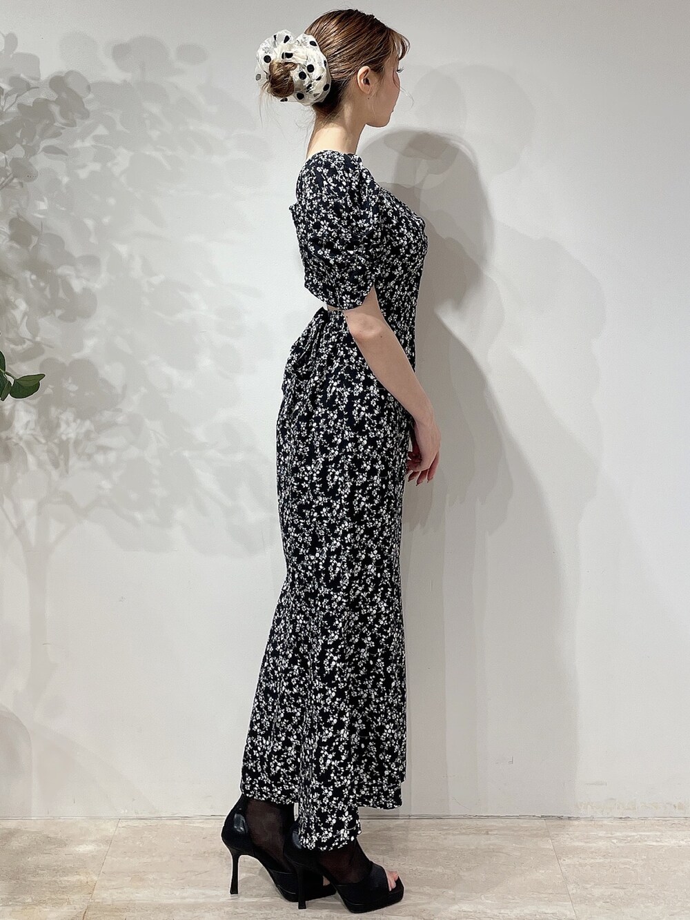 ブラック系のワンピース、ブラック系のブーツ、ベージュ系のシュシュを着用したレディースの春コーディネートの3枚目の写真