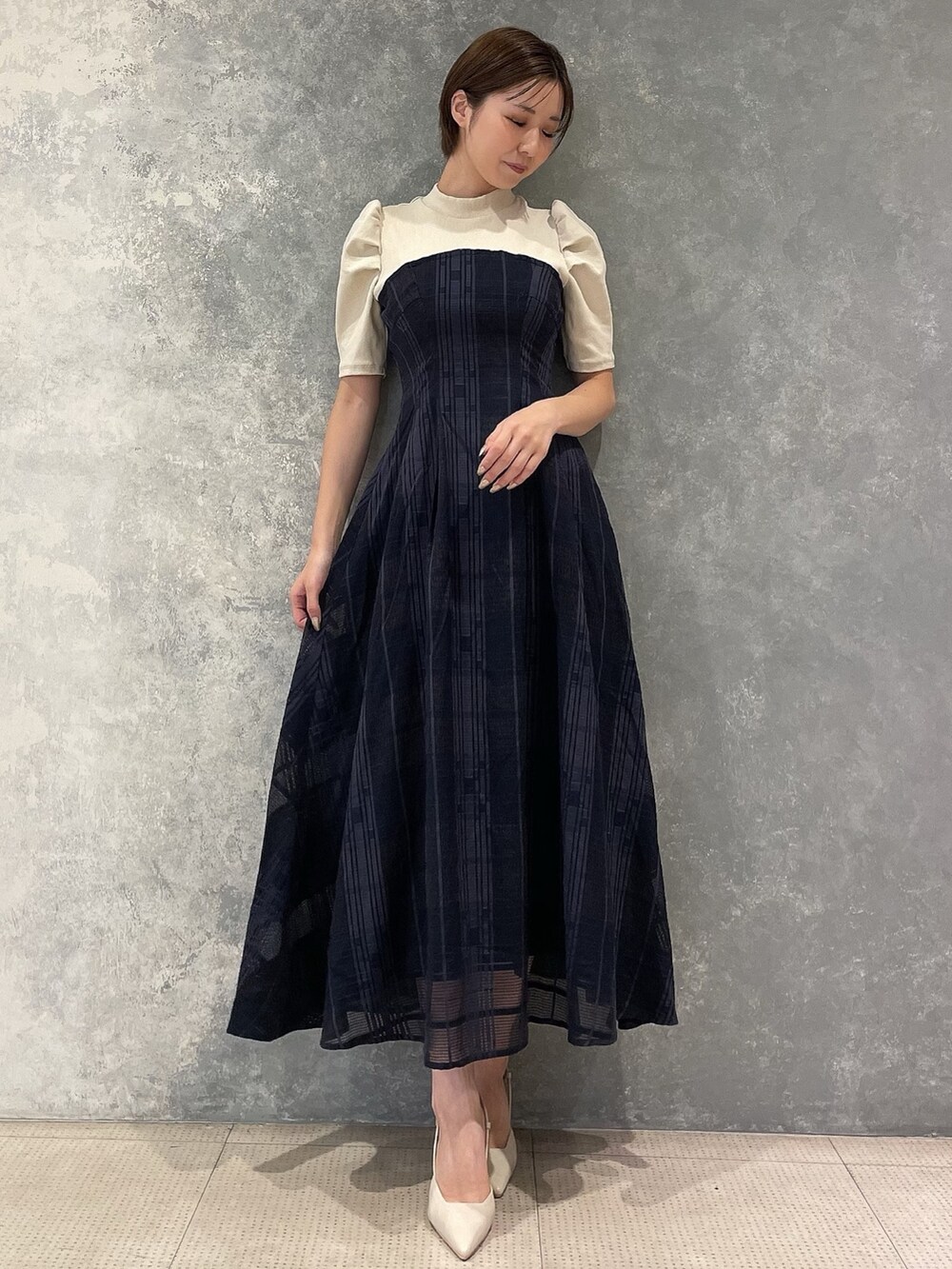 ホワイト系のライダースジャケット、ベージュ系のサンダル、ブルー系のワンピースを着用したレディースの夏コーディネートの3枚目の写真