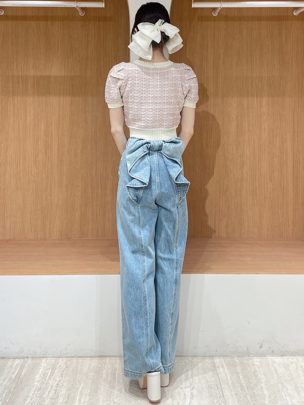 ピンク系のニット/セーター、ブルー系のデニムパンツ、ホワイト系のサンダルを着用したレディースの春コーディネートの4枚目の写真