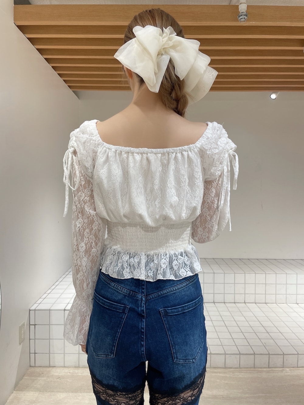 ホワイト系のシャツ/ブラウス、ブルー系のデニムパンツ、ホワイト系のブーツを着用したレディースの春コーディネートの7枚目の写真