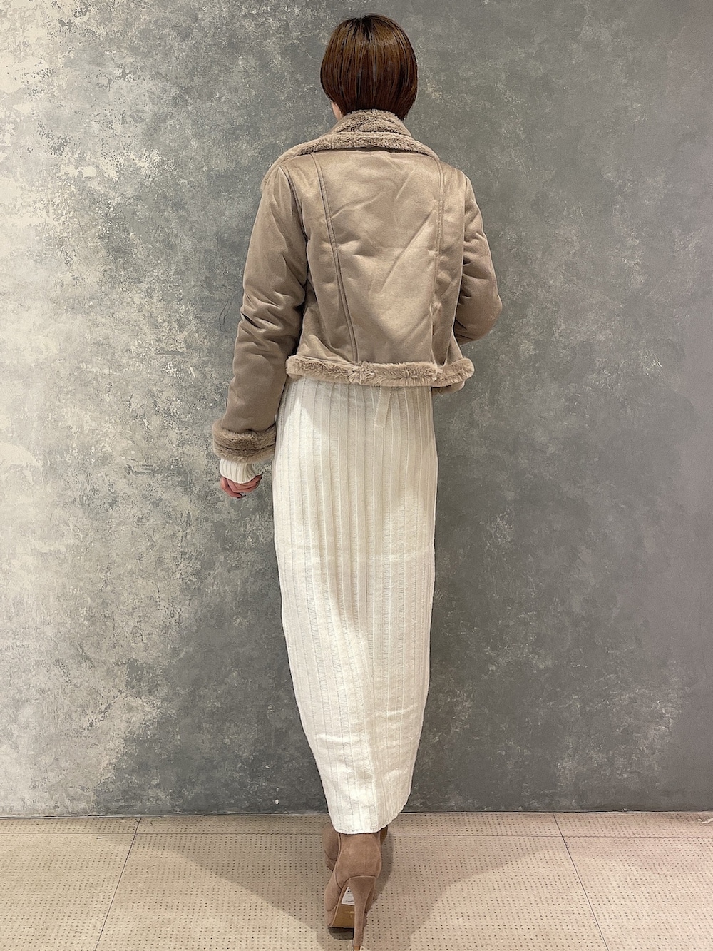 ベージュ系のブルゾン、ホワイト系のワンピース、ベージュ系のブーツを着用したレディースの秋コーディネートの4枚目の写真