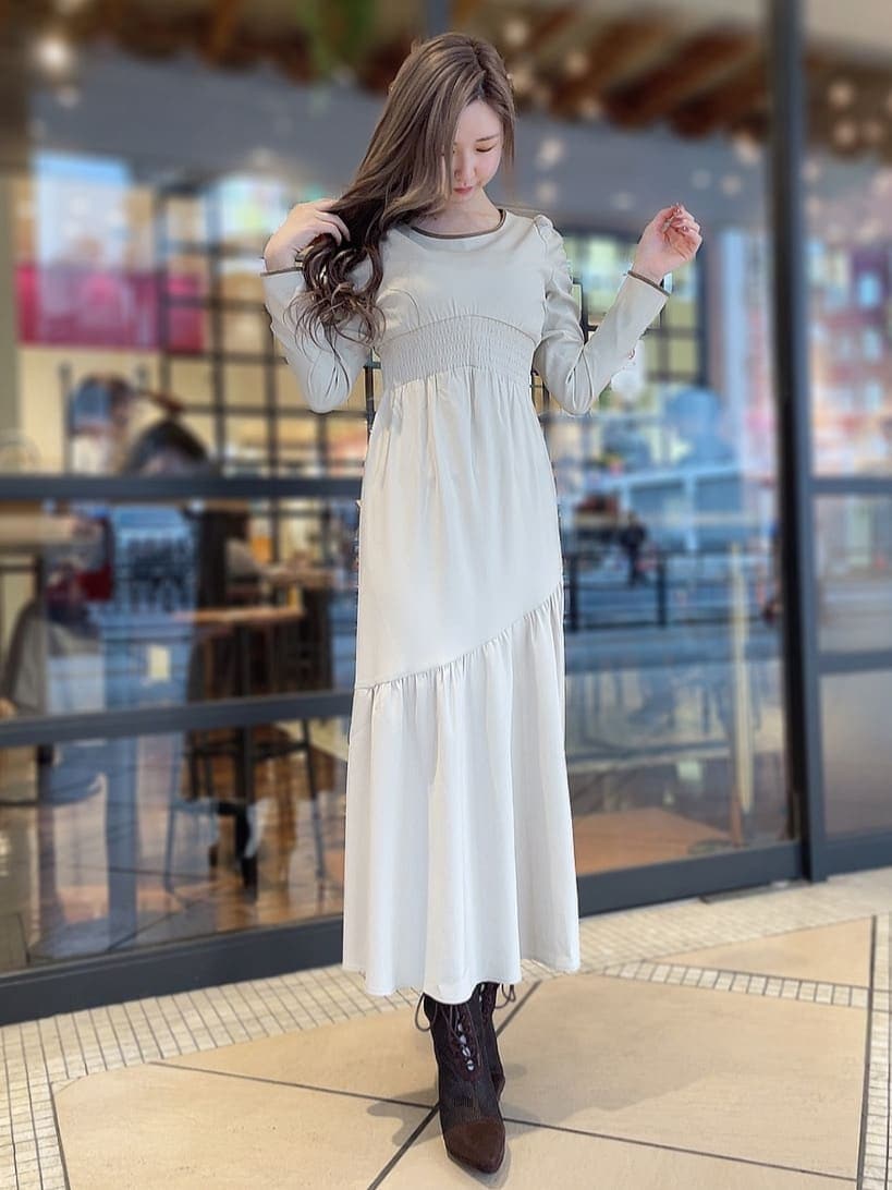 ベージュ系のワンピース、パープル系のトレンチコート、ブラウン系のブーツを着用したレディースの冬コーディネートの5枚目の写真