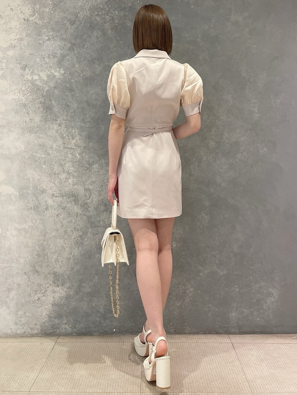 ホワイト系のワンピース、ホワイト系のハンドバッグ、ホワイト系のサンダルを着用したレディースの春コーディネートの4枚目の写真