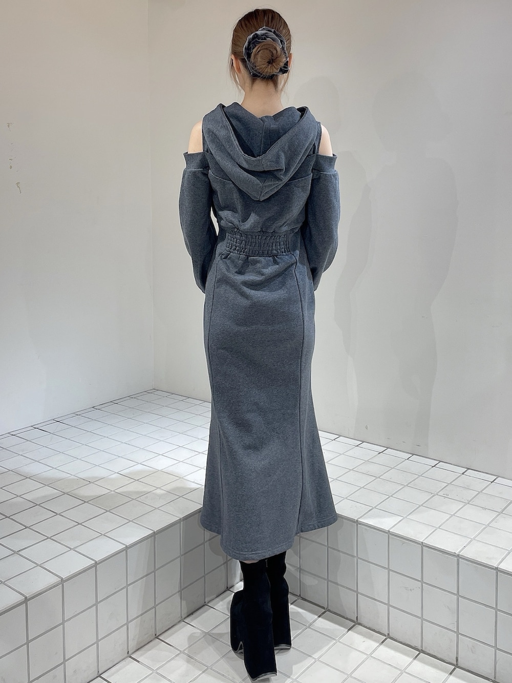 グレー系のワンピース、ブラック系のブーツ、グレー系のシュシュを着用したレディースの秋コーディネートの3枚目の写真