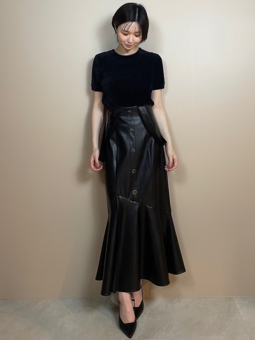 ブラック系のニット/セーター、ブラック系のスカート、ブラック系のサンダルを着用したレディースの夏コーディネートの2枚目の写真