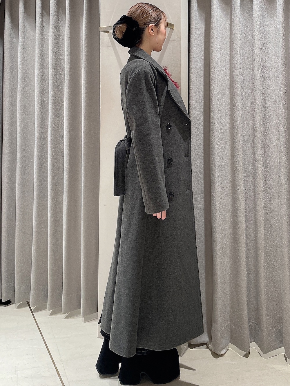 レッド系のニット/セーター、ブラック系のデニムパンツ、ブラック系のブーツを着用したレディースの秋コーディネートの5枚目の写真