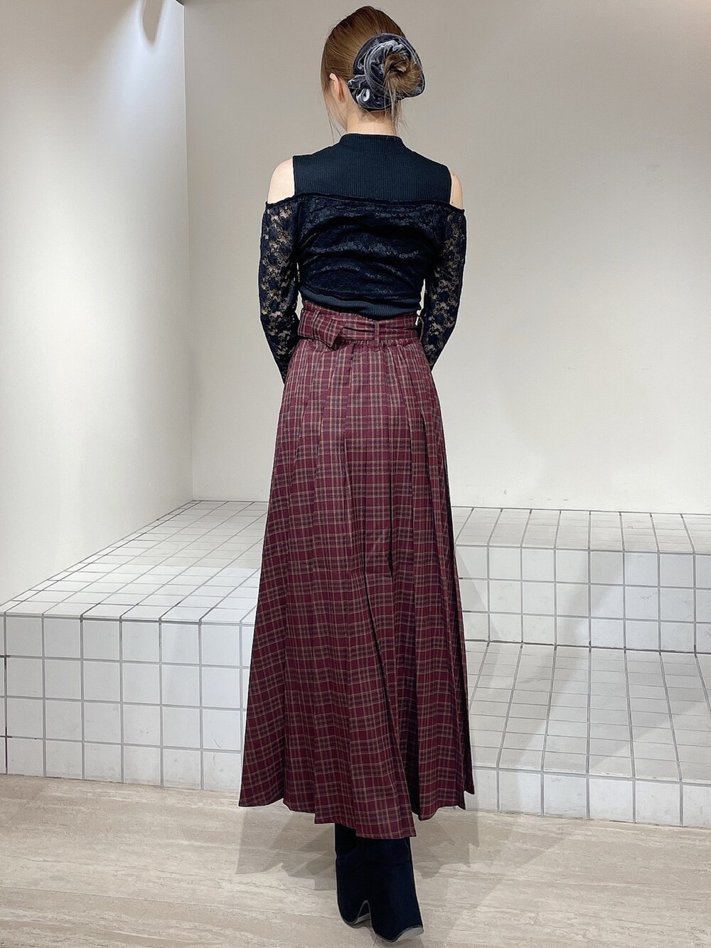 ブラック系のTシャツ/カットソー、レッド系のスカート、ブラック系のブーツを着用したレディースの秋コーディネートの3枚目の写真