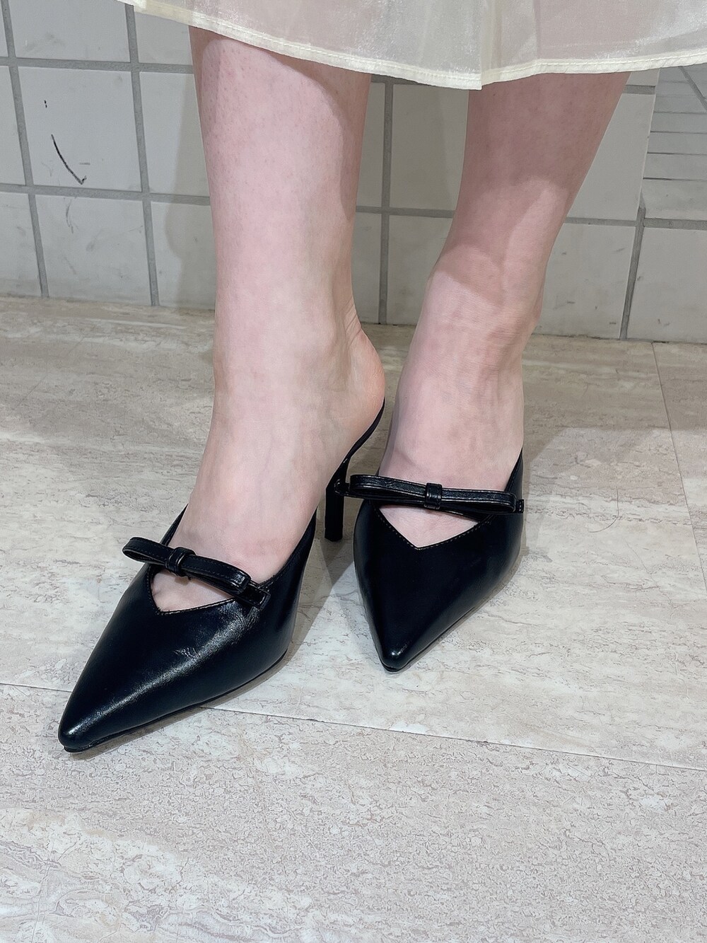 ブラック系のパンプス、ホワイト系のスカート、ブラック系のタンクトップを着用したレディースの夏コーディネートの7枚目の写真