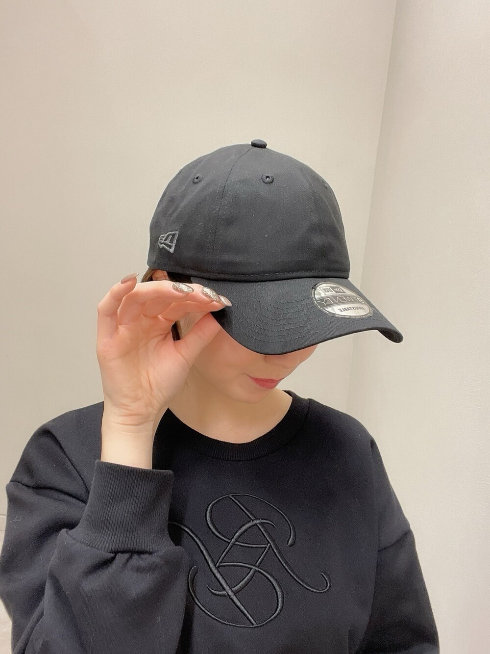 ホワイト系のスニーカー、ブラック系のスウェット、ブラック系のスカートを着用したレディースの冬コーディネートの5枚目の写真