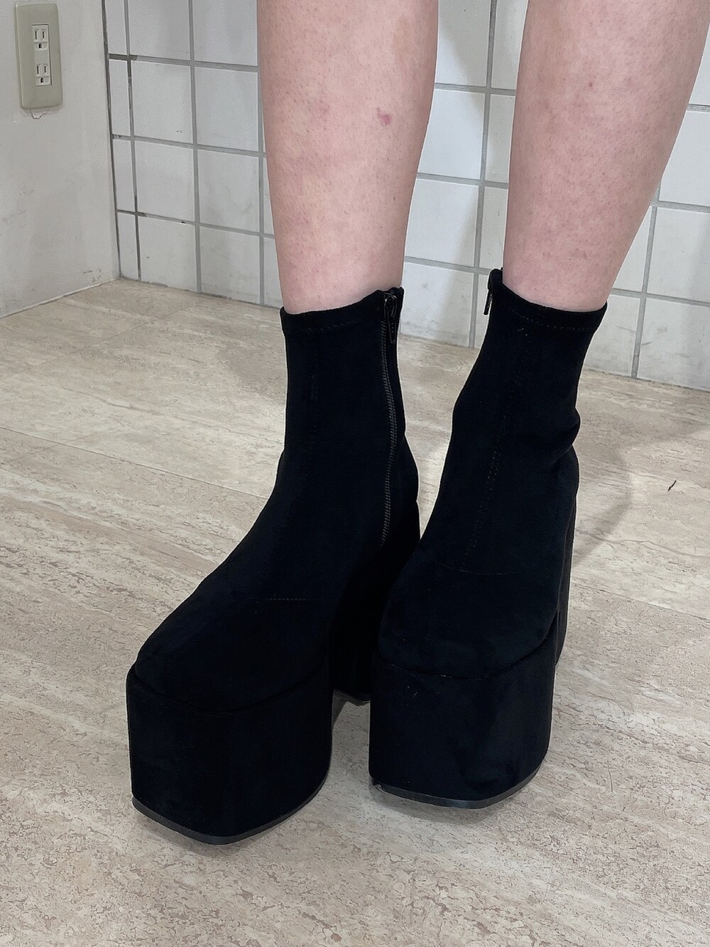 ホワイト系のダウンジャケット/コート、グレー系のワンピース、ブラック系のブーツを着用したレディースの秋コーディネートの7枚目の写真