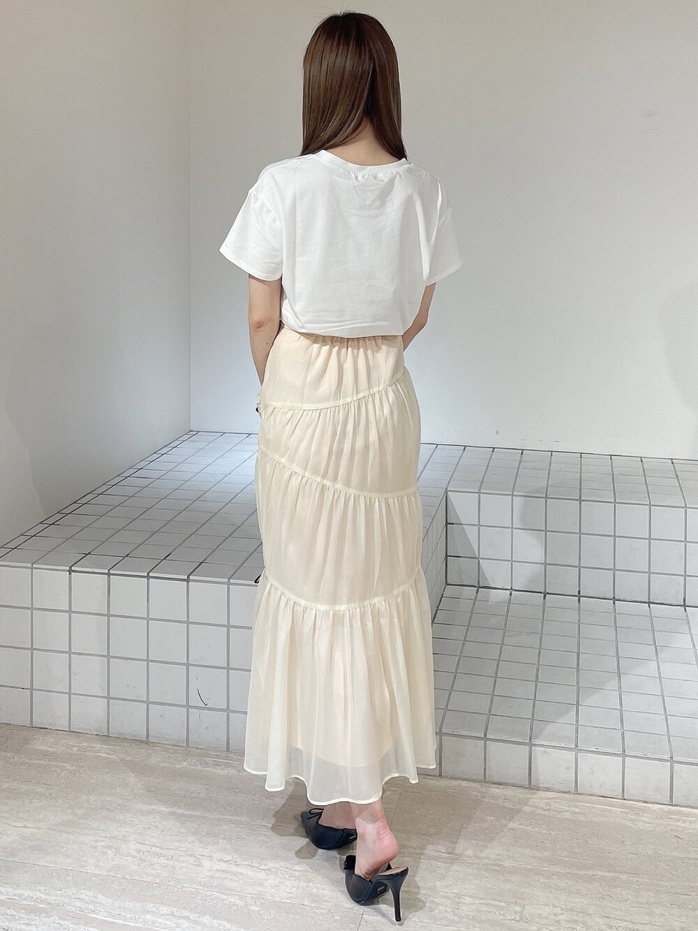 ホワイト系のTシャツ/カットソー、ホワイト系のスカート、ブラック系のパンプスを着用したレディースの夏コーディネートの4枚目の写真