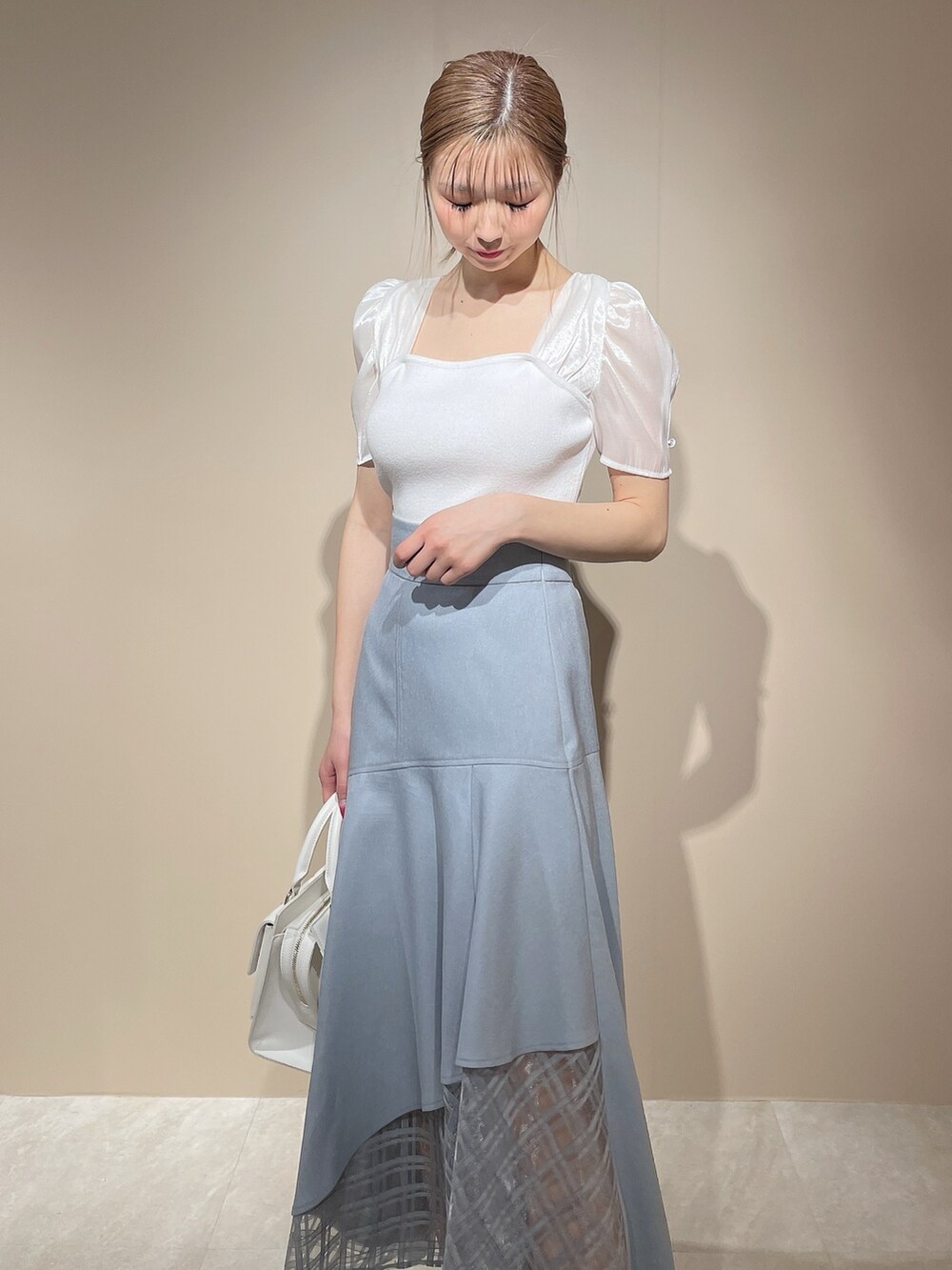 ホワイト系のニット/セーター、ブルー系のスカートを着用したレディースの春コーディネートの5枚目の写真