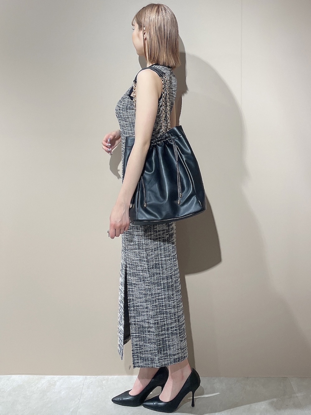 ブラック系のワンピース、ブラック系のトートバッグを着用したレディースの夏コーディネートの3枚目の写真