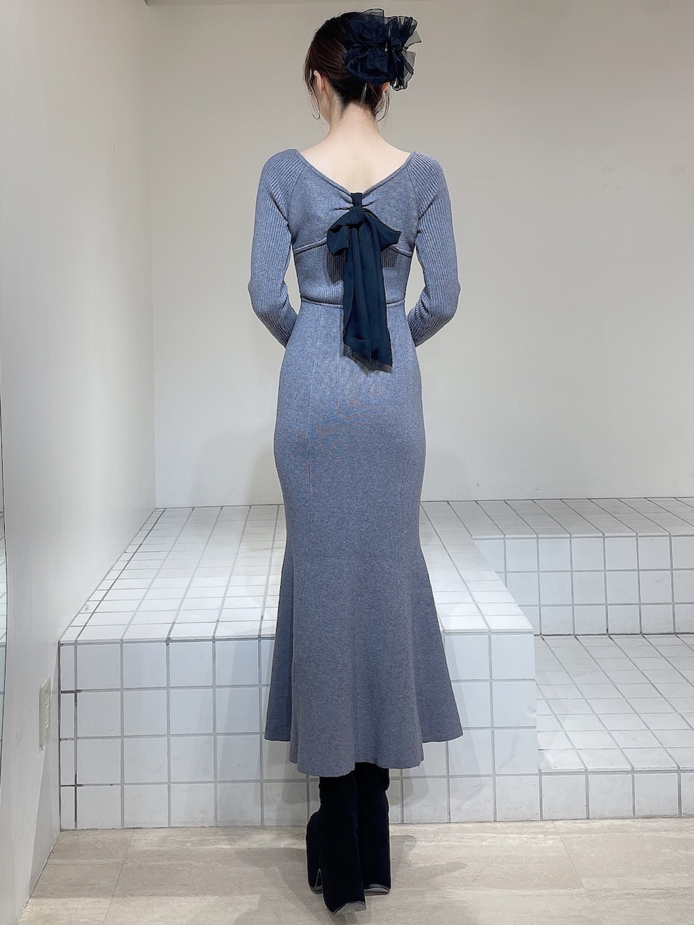 グレー系のワンピース、ブラック系のブーツ、ブラック系のバレッタ/ヘアクリップを着用したレディースの冬コーディネートの6枚目の写真