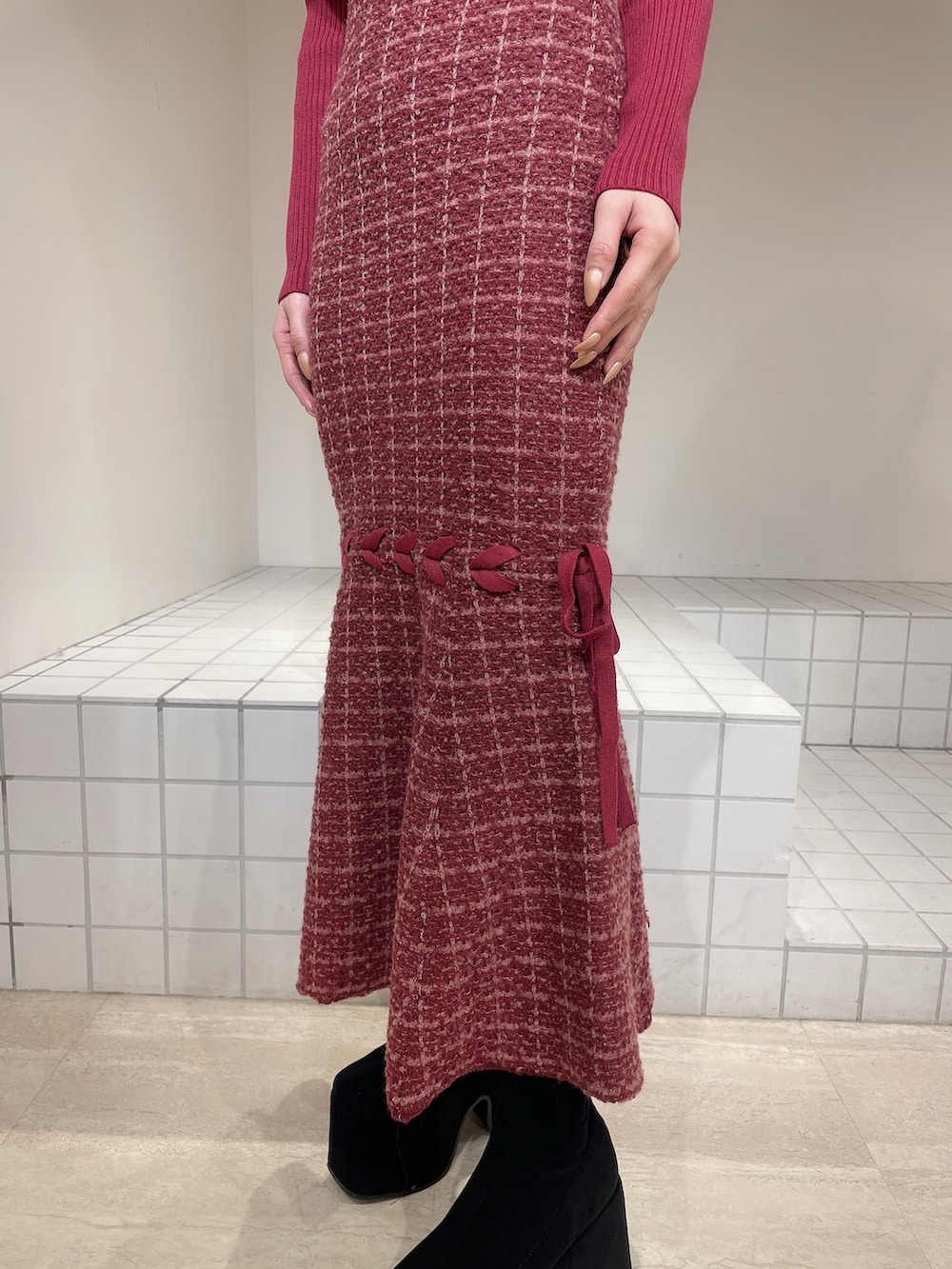 レッド系のワンピース、ブラック系のブーツ、ブラック系のバレッタ/ヘアクリップを着用したレディースの冬コーディネートの5枚目の写真