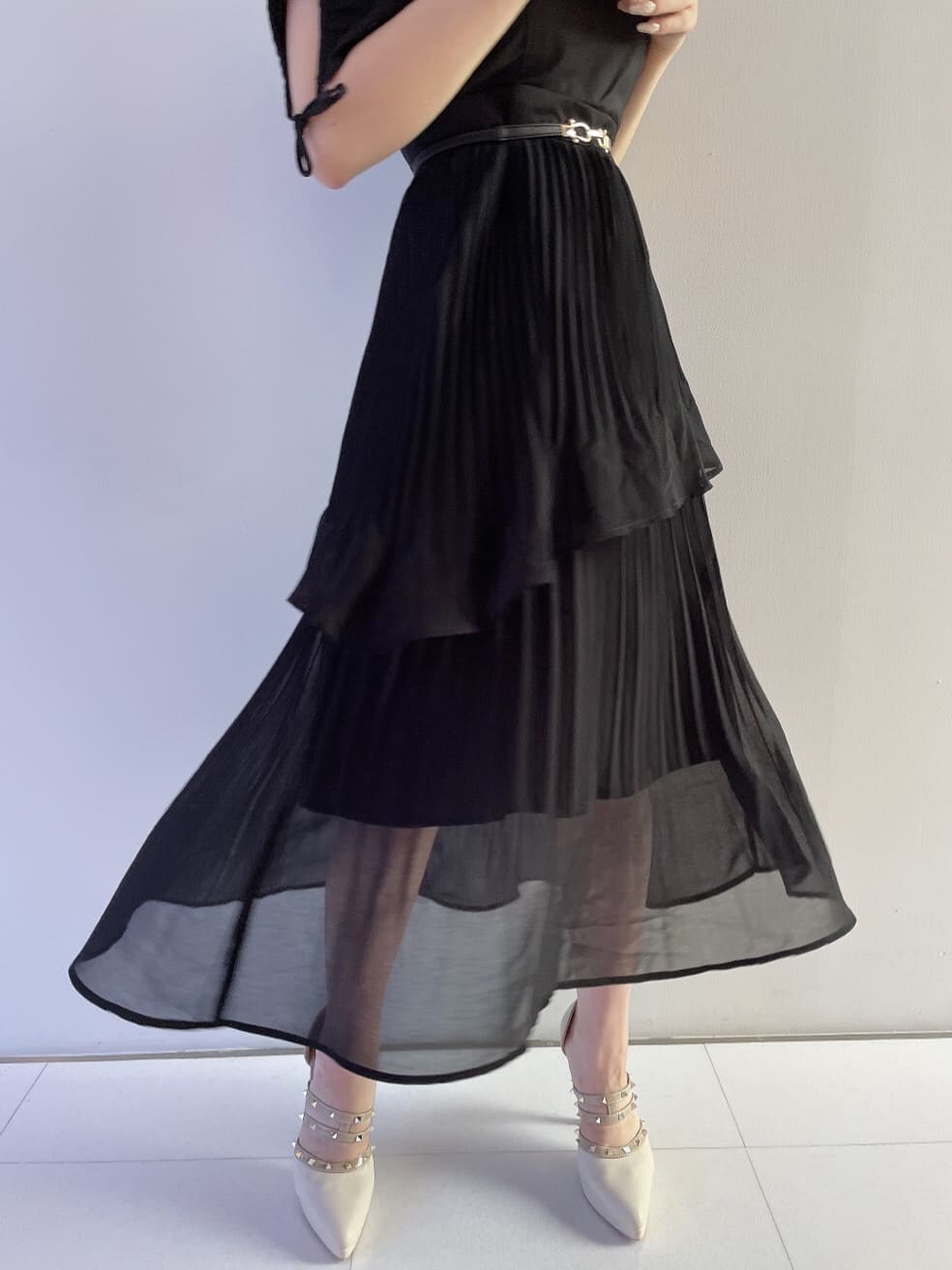 ホワイト系のハンドバッグ、ブラック系のワンピース、ベージュ系のパンプスを着用したレディースの夏コーディネートの5枚目の写真