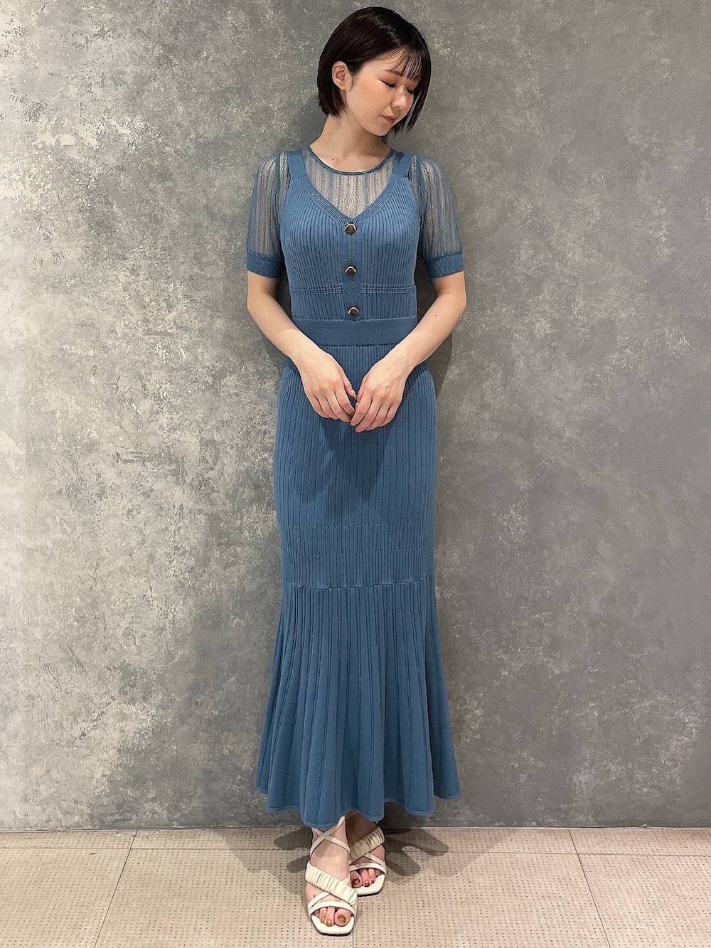 ホワイト系のサンダル、ブルー系のワンピースを着用したレディースの春コーディネートの2枚目の写真