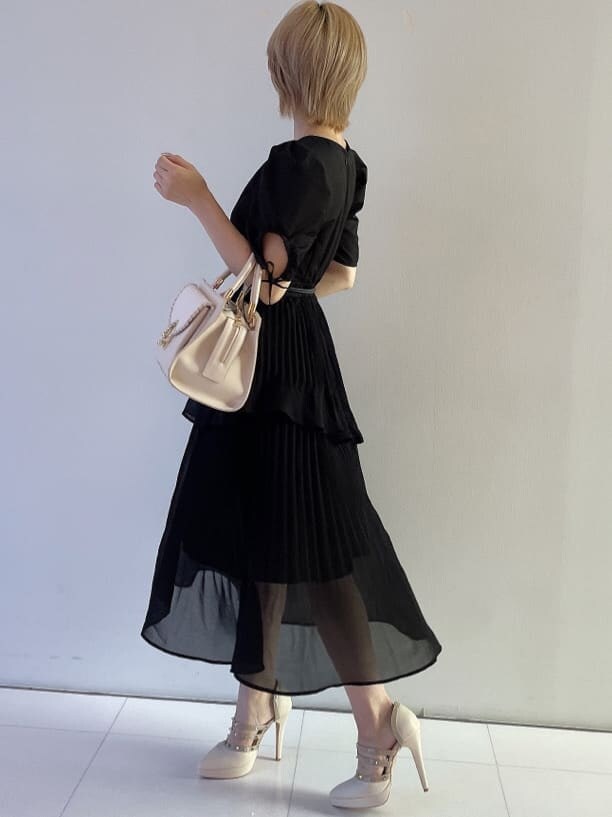 ホワイト系のハンドバッグ、ブラック系のワンピース、ベージュ系のパンプスを着用したレディースの夏コーディネートの3枚目の写真