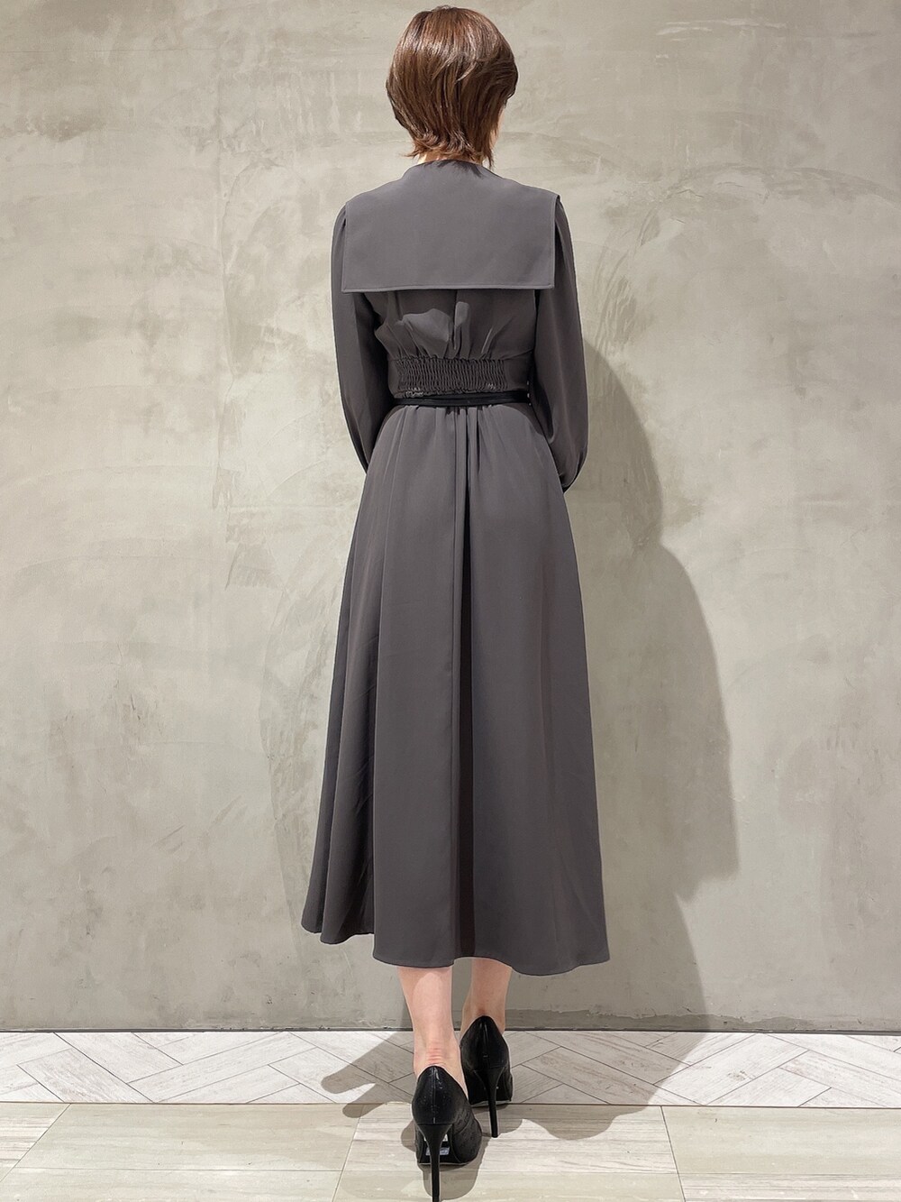 ベージュ系のその他アウター、グレー系のワンピース、ブラック系のハンドバッグを着用したレディースの冬コーディネートの6枚目の写真