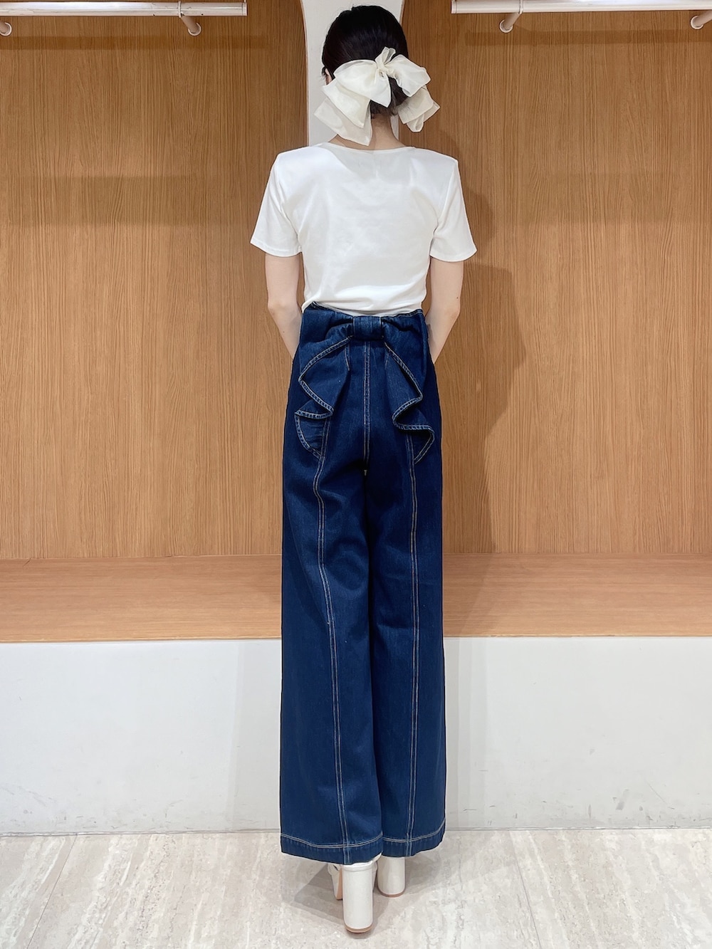 ホワイト系のTシャツ/カットソー、ブルー系のデニムパンツ、ホワイト系のサンダルを着用したレディースの春コーディネートの3枚目の写真