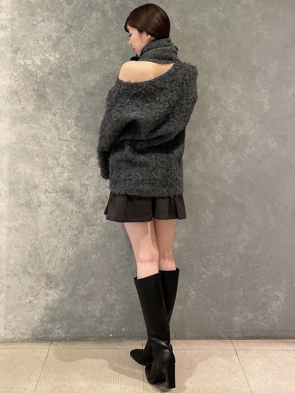 グレー系のワンピース、グレー系のスカート、ブラック系のブーツを着用したレディースの秋コーディネートの3枚目の写真