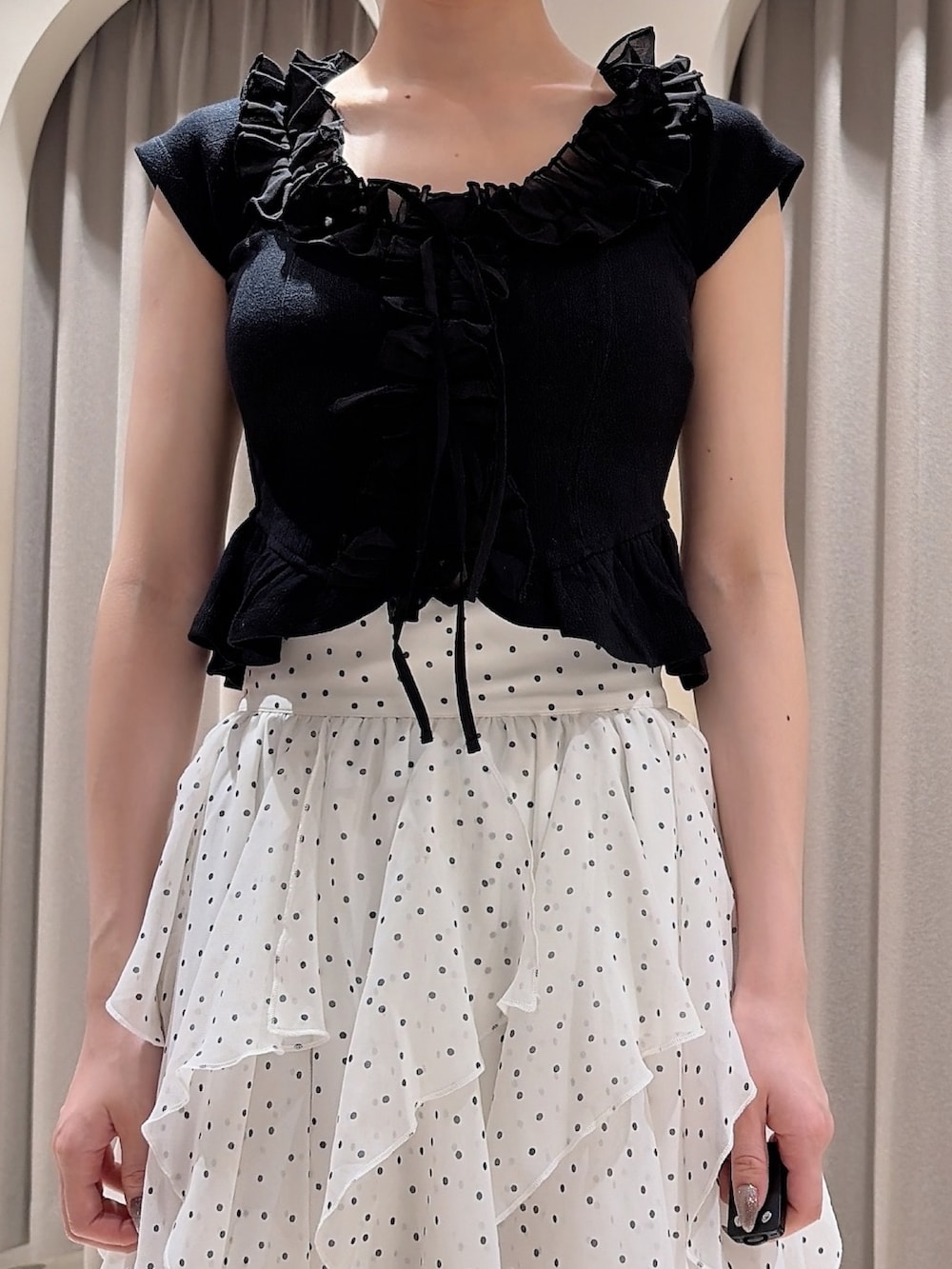 ブラック系のTシャツ/カットソー、ホワイト系のスカート、ブラック系のパンプスを着用したレディースの夏コーディネートの5枚目の写真