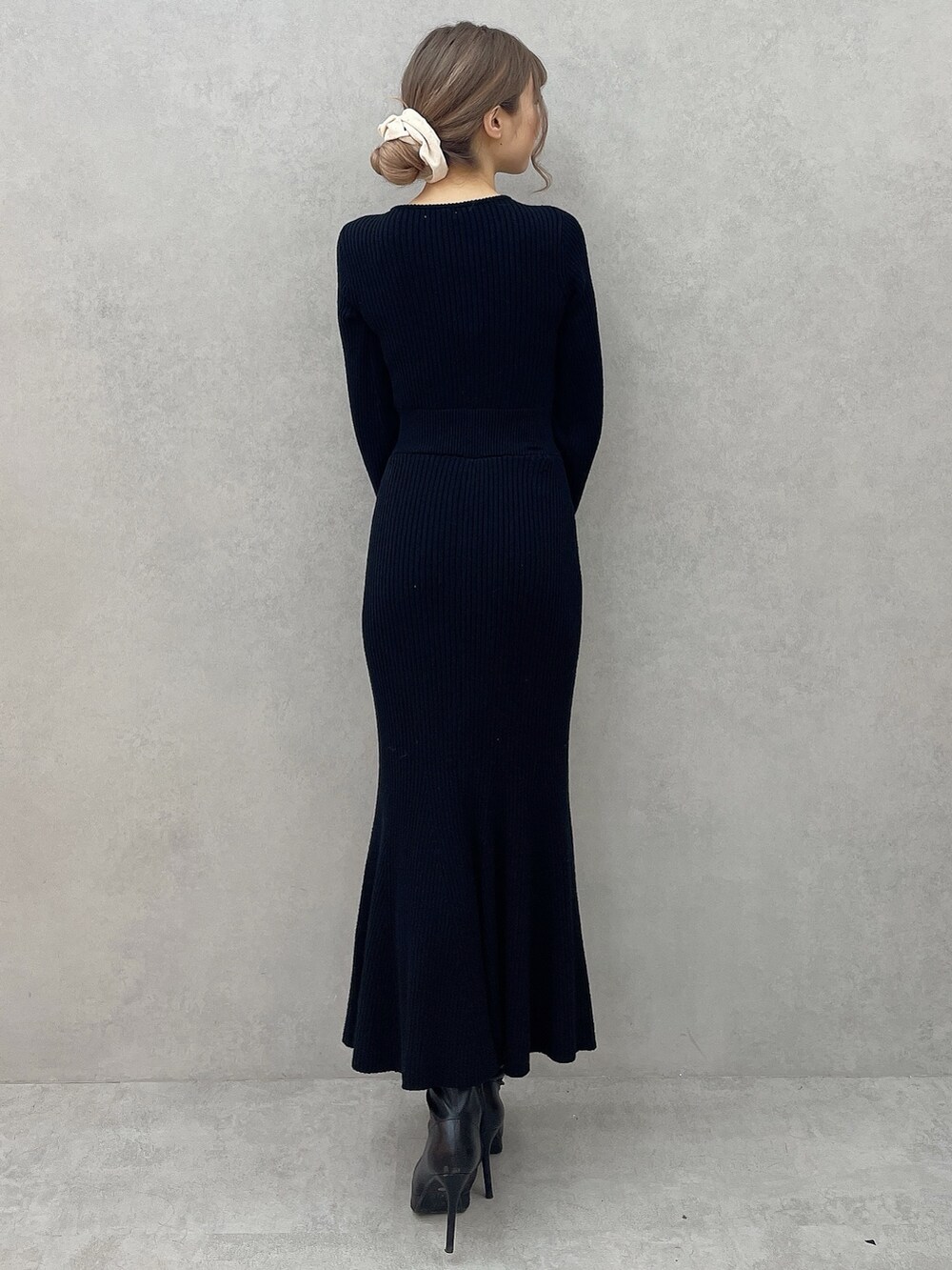 ブラック系のワンピース、ブラック系のブーツを着用したレディースの秋コーディネートの5枚目の写真