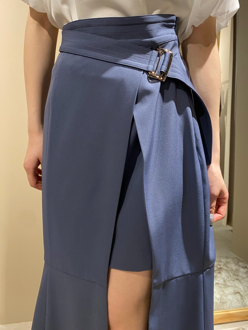 ホワイト系のニット/セーター、ブルー系のスカート、ホワイト系のパンプスを着用したレディースの春コーディネートの7枚目の写真