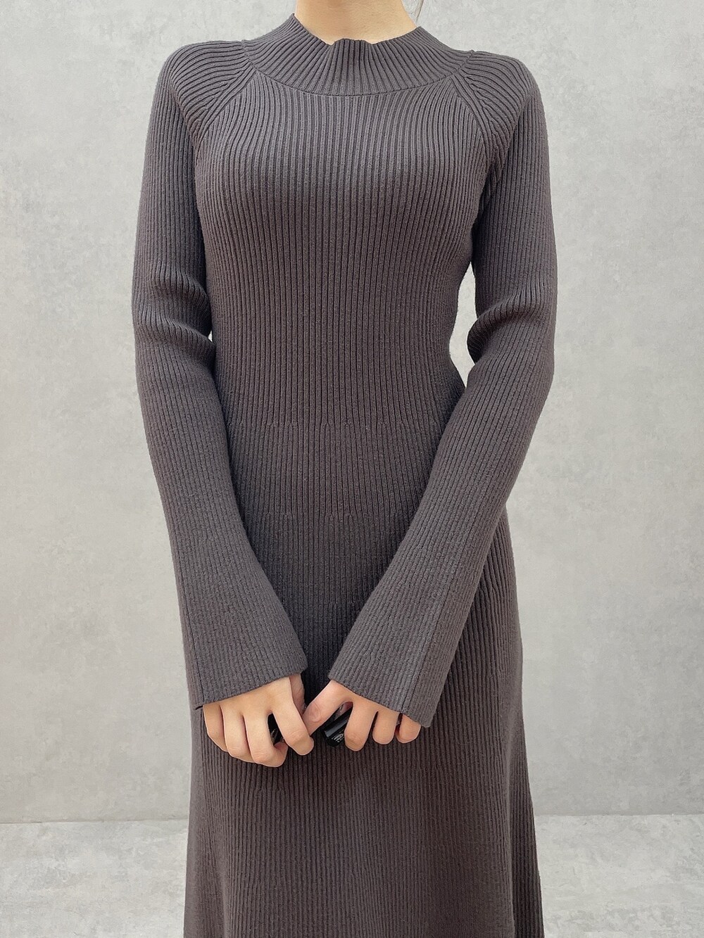 グレー系のワンピース、ブラック系のハンドバッグ、ブラック系のブーツを着用したレディースの秋コーディネートの7枚目の写真