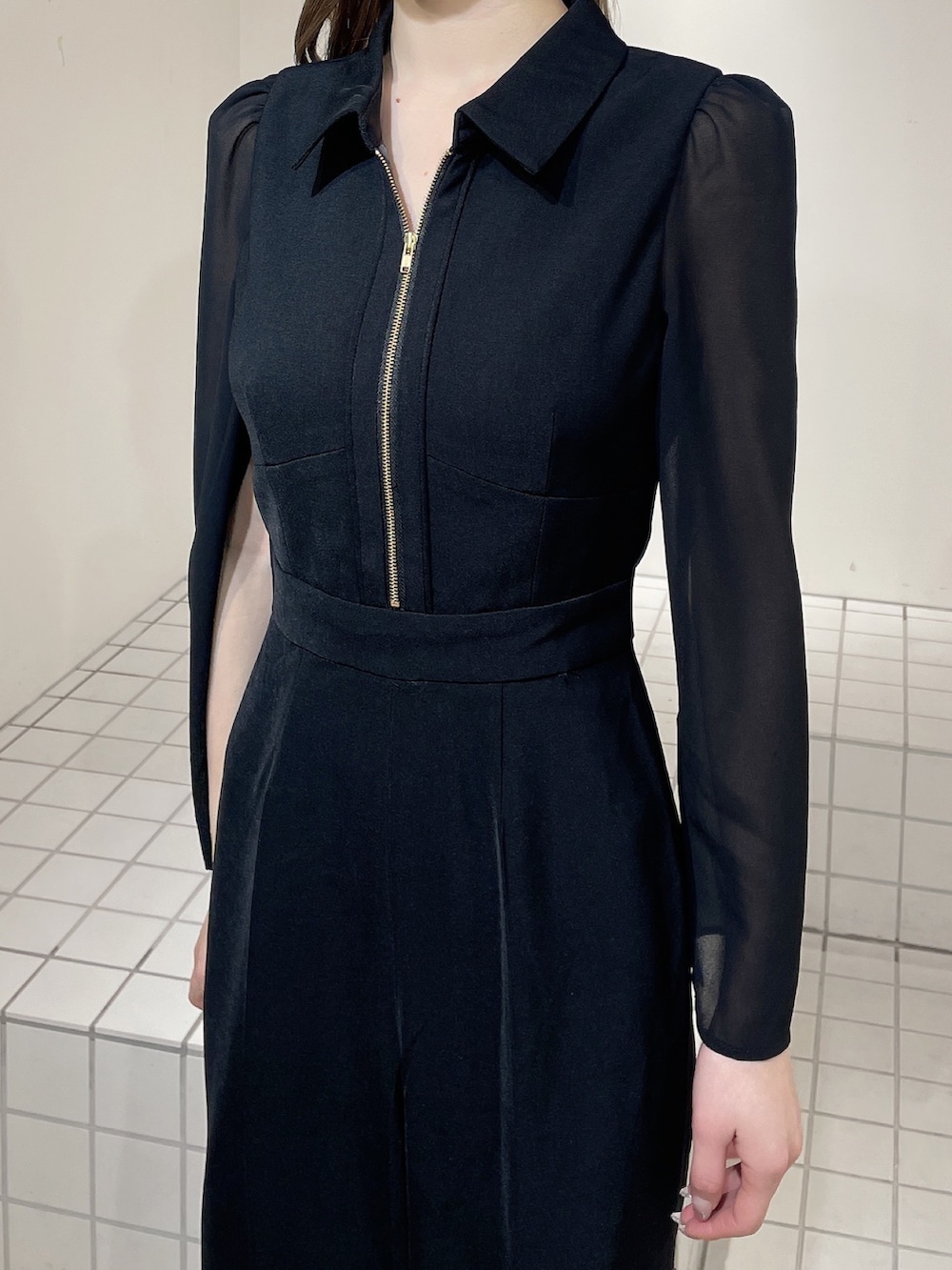 ブラック系のワンピース、ブラック系のブーツ、ブラック系のハンドバッグを着用したレディースの冬コーディネートの5枚目の写真