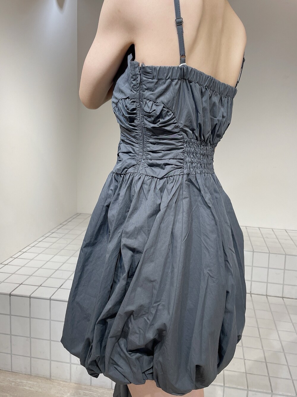 グレー系のワンピース、ブラック系のブーツ、グレー系のシュシュを着用したレディースの秋コーディネートの7枚目の写真