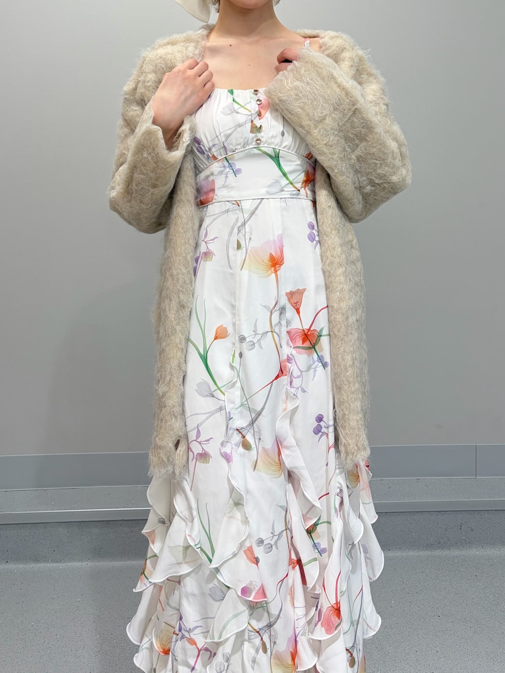 ベージュ系のカーディガン/ボレロ、ホワイト系のワンピース、ホワイト系のパンプスを着用したレディースの冬コーディネートの5枚目の写真