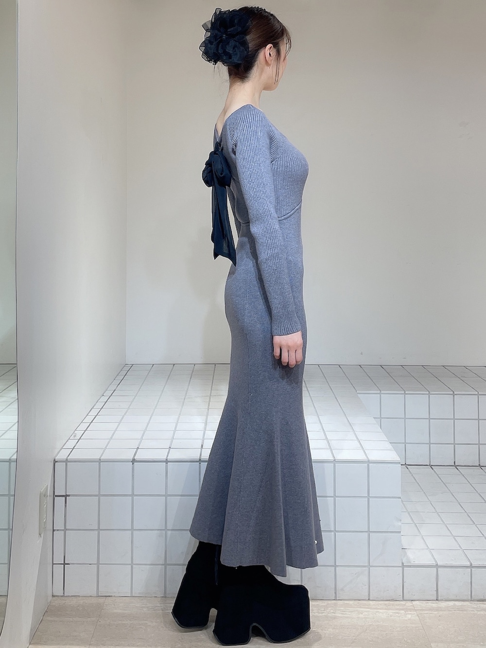 グレー系のワンピース、ブラック系のブーツ、ブラック系のバレッタ/ヘアクリップを着用したレディースの冬コーディネートの4枚目の写真