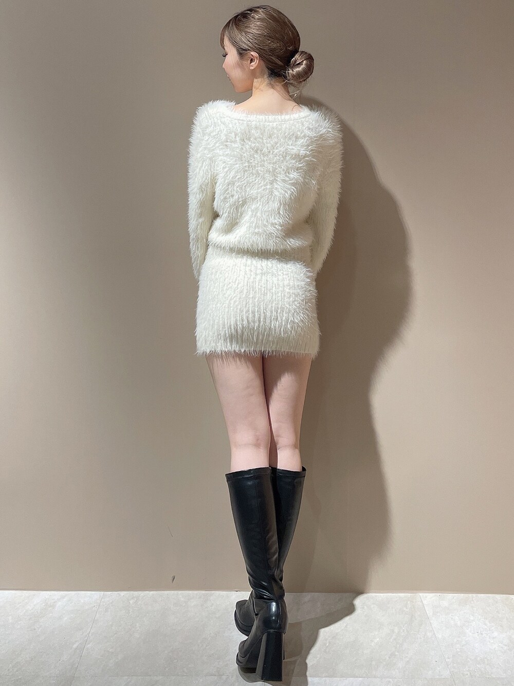 ホワイト系のワンピース、ブラック系のブーツを着用したレディースの秋コーディネートの5枚目の写真