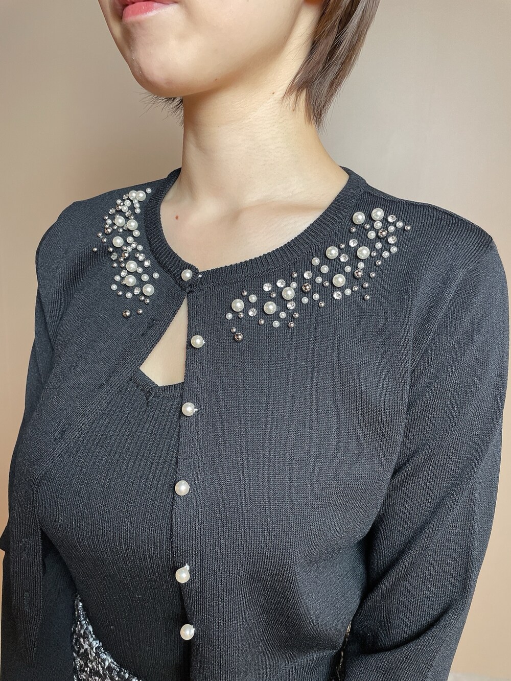 ホワイト系のハンドバッグ、ブラック系のカーディガン/ボレロ、ブラック系のスカートを着用したレディースの冬コーディネートの8枚目の写真