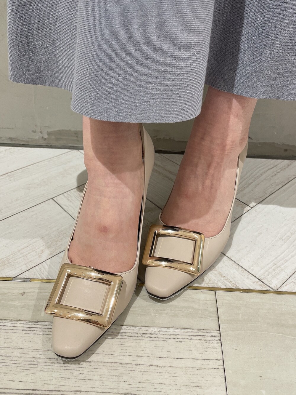 ホワイト系のテーラードジャケット、ブラウン系のハンドバッグ、ホワイト系のパンプスを着用したレディースの春コーディネートの8枚目の写真