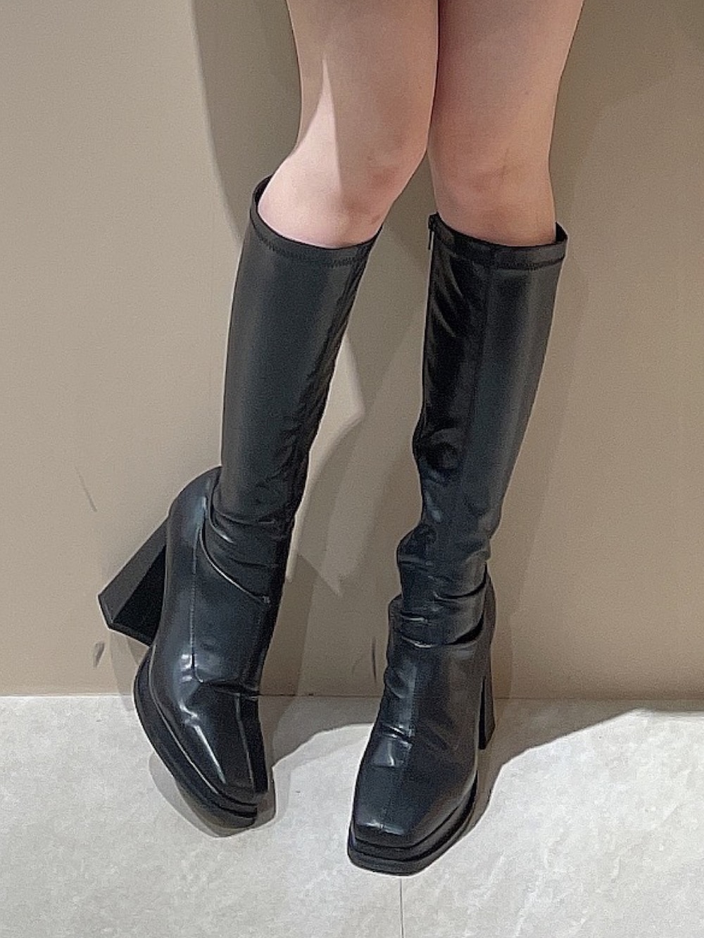 グレー系のテーラードジャケット、グレー系のスカート、ホワイト系のニット/セーターを着用したレディースの秋コーディネートの9枚目の写真