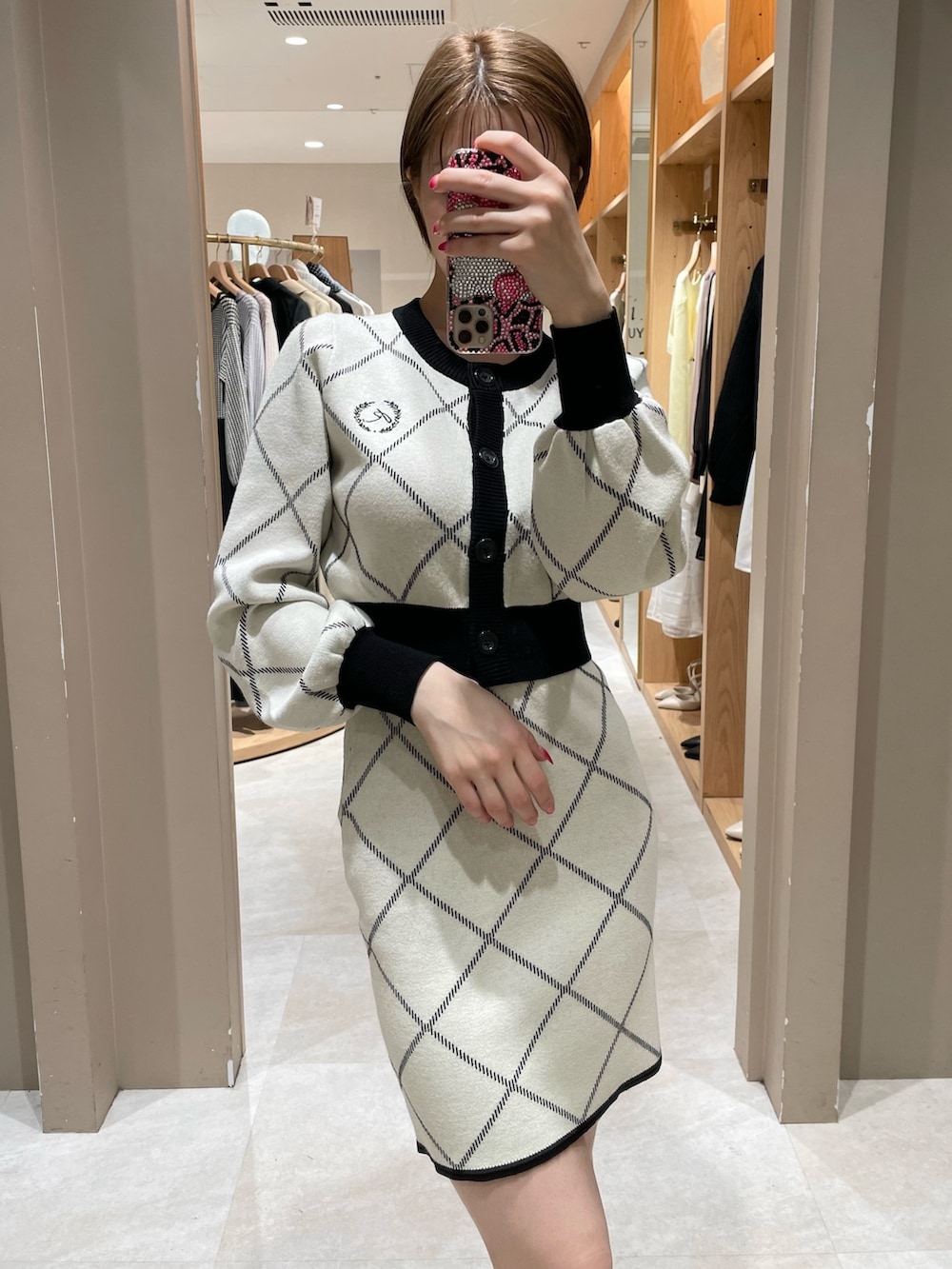 ホワイト系のカーディガン/ボレロ、ホワイト系のスカート、ブラック系のパンプスを着用したレディースの冬コーディネートの3枚目の写真