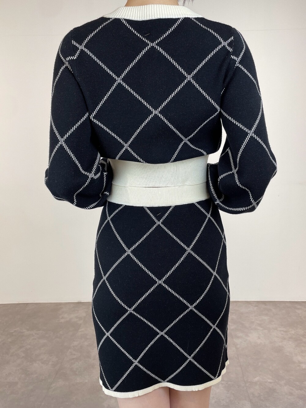 ブラック系のカーディガン/ボレロ、ブラック系のスカート、ブラウン系のブーツを着用したレディースの冬コーディネートの7枚目の写真