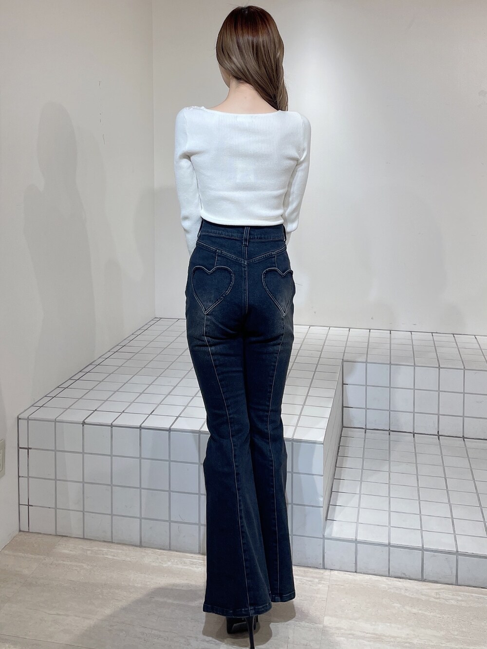 グレー系のカーディガン/ボレロ、ホワイト系のニット/セーター、ブラック系のデニムパンツを着用したレディースの冬コーディネートの7枚目の写真