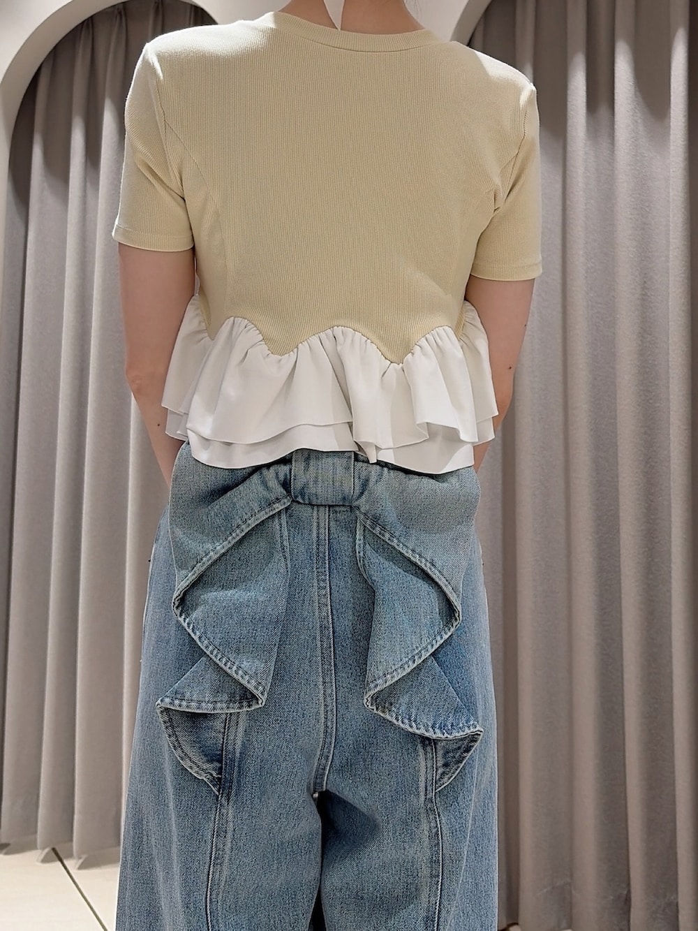 イエロー系のカーディガン/ボレロ、ホワイト系のトートバッグ、ブルー系のデニムパンツを着用したレディースの夏コーディネートの6枚目の写真