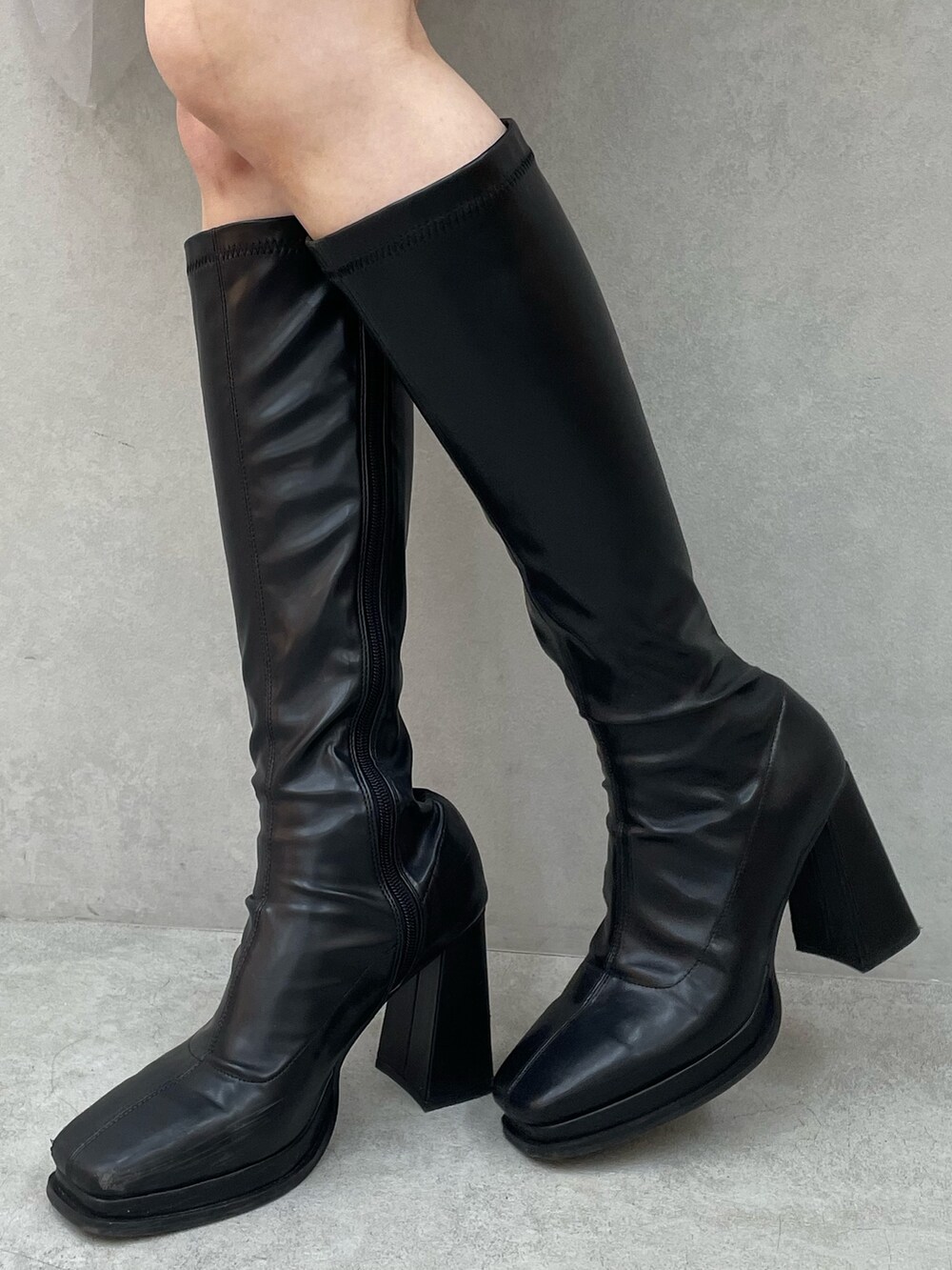 レッド系のニット/セーター、ブラック系のスカート、ブラック系のブーツを着用したレディースの秋コーディネートの6枚目の写真